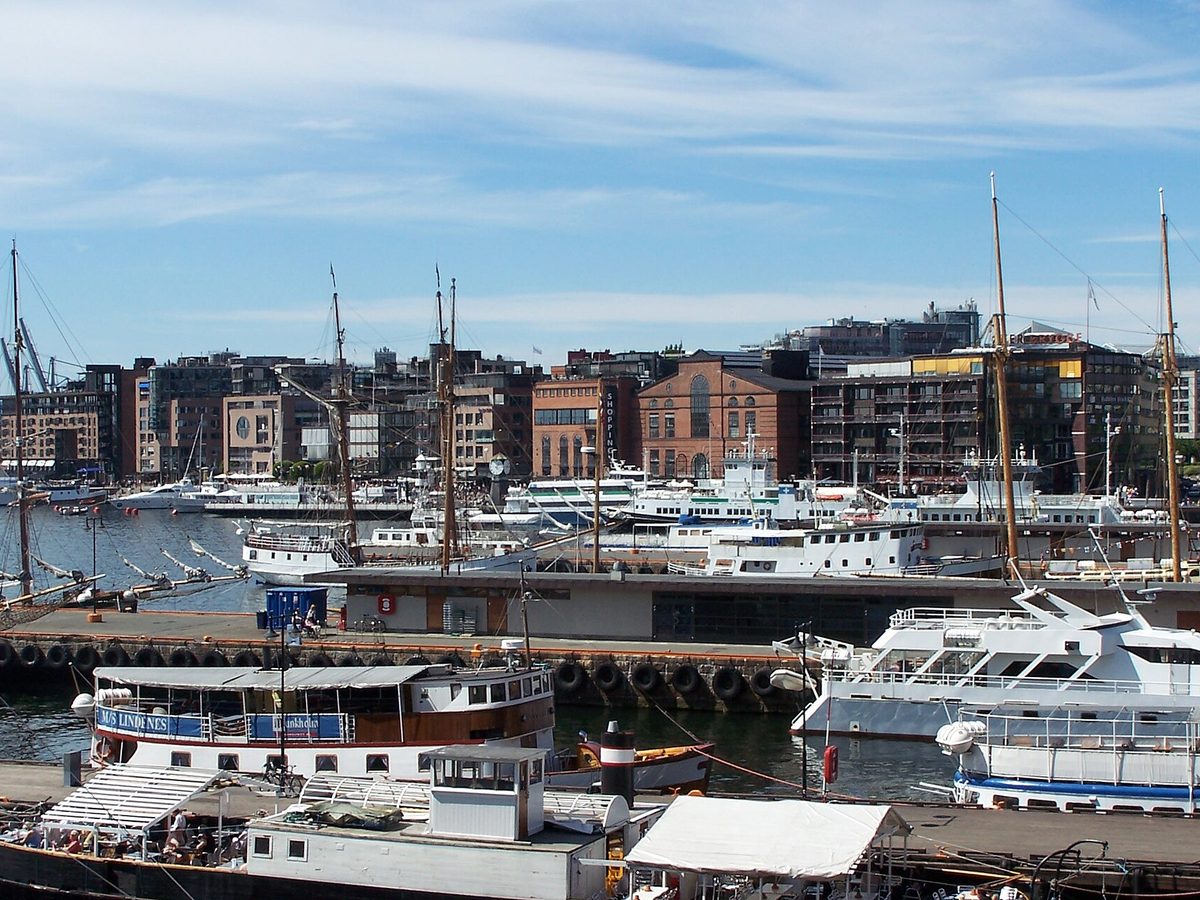 Aker Brygge i Oslo sett over havnebassenget, med båter og teglsteinsbygg