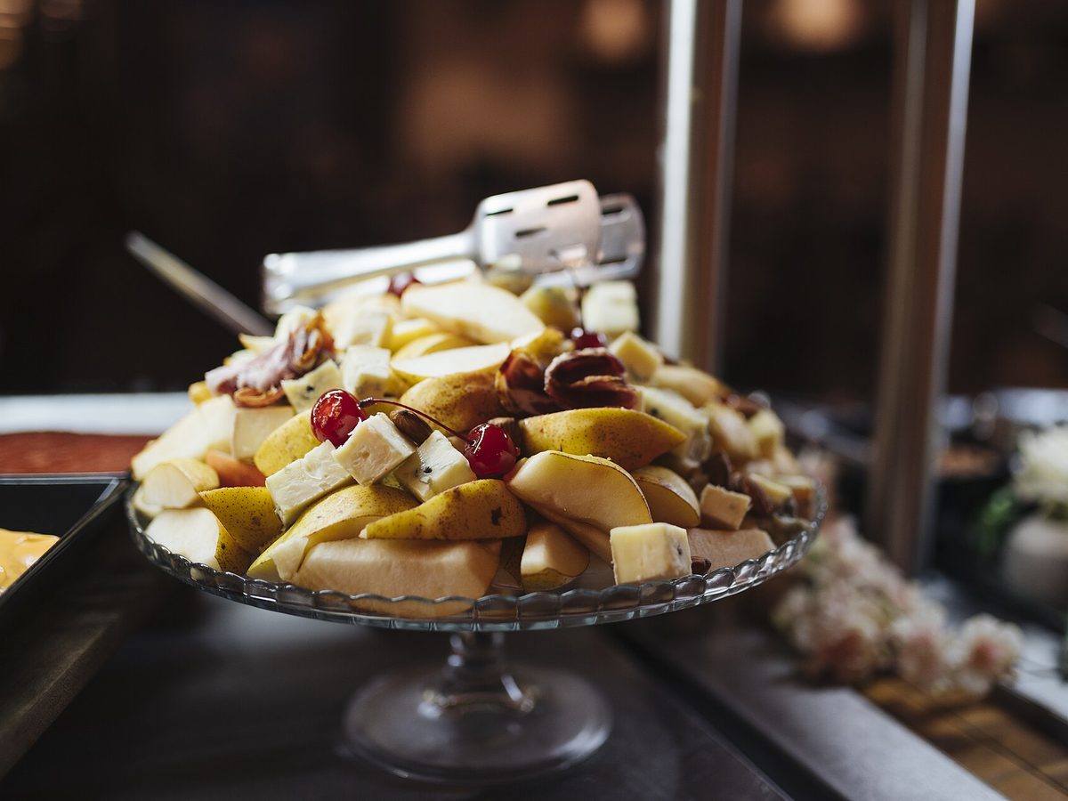 Fat med oppskåret frukt og ost satt frem på en pausebuffet