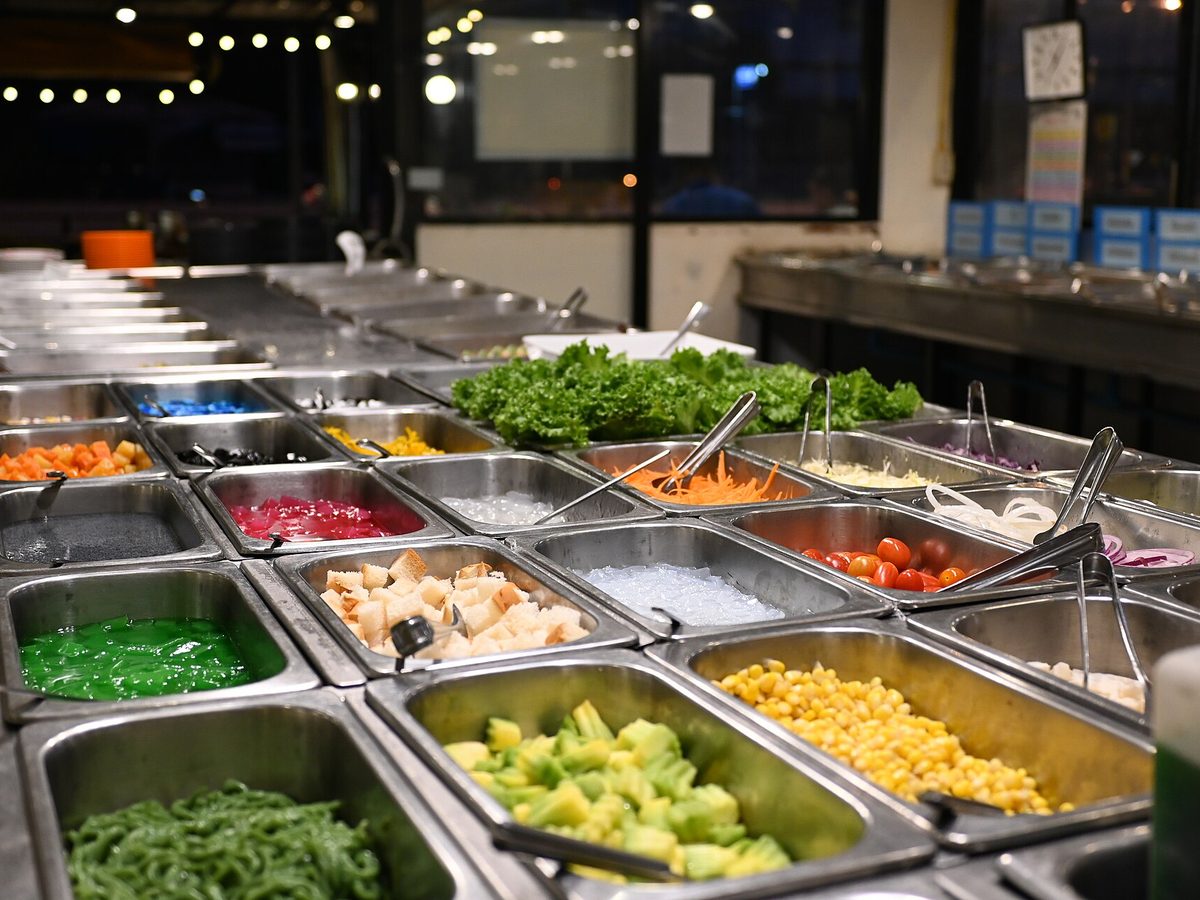Buffet med salater og grønnsaker i stålbeholdere
